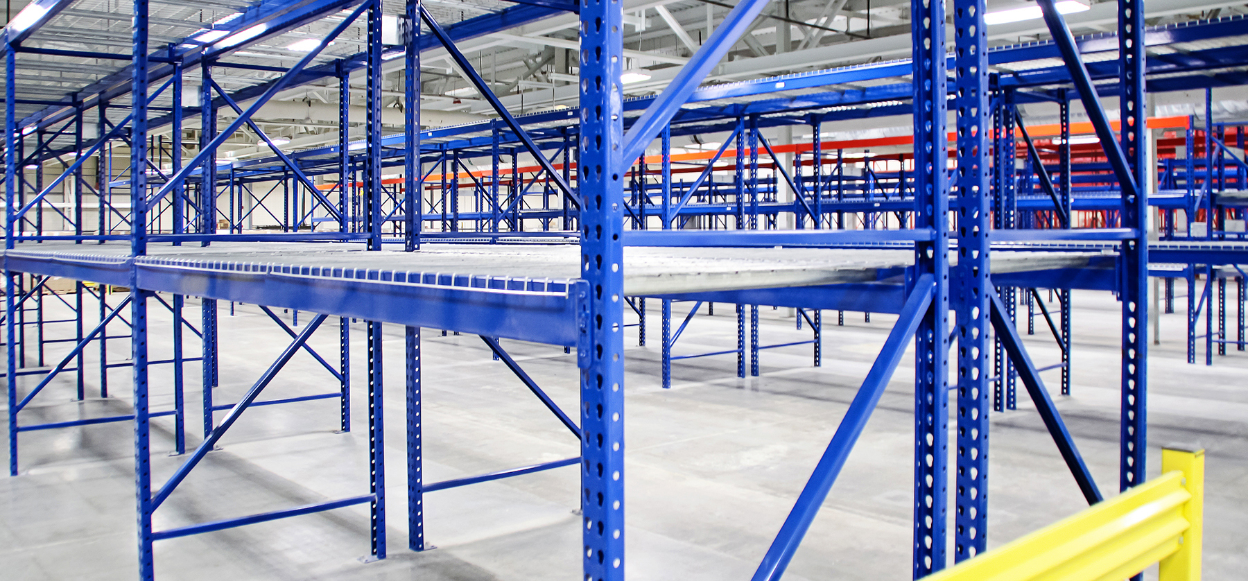 Custom colored galvanized pallet racks with mesh decking in a warehouse